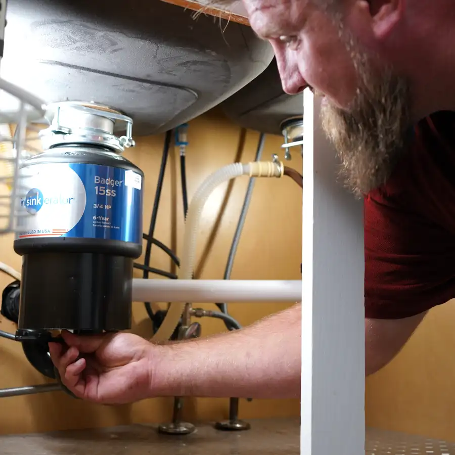 Plumber fixing a garbage disposal