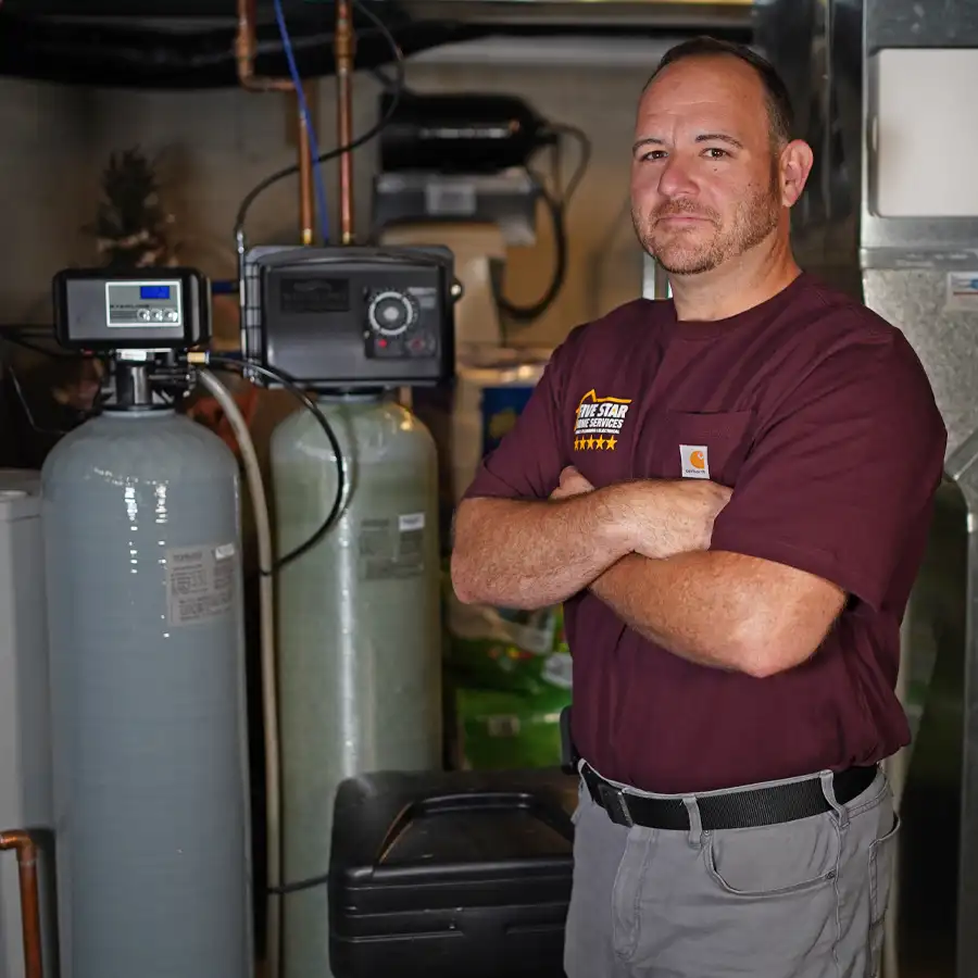 Plumber standing next to water softener